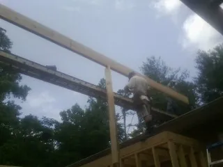 Carpenter setting a ridge beam over a new addition frame — Ice Dam Removal by Roofing Brothers in La Fayette