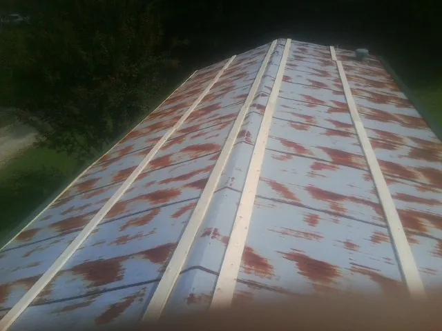Rusted metal roof panels with new wood purlins before replacement — Storm Damage Roof Repair in La Fayette by Roofing Brothers